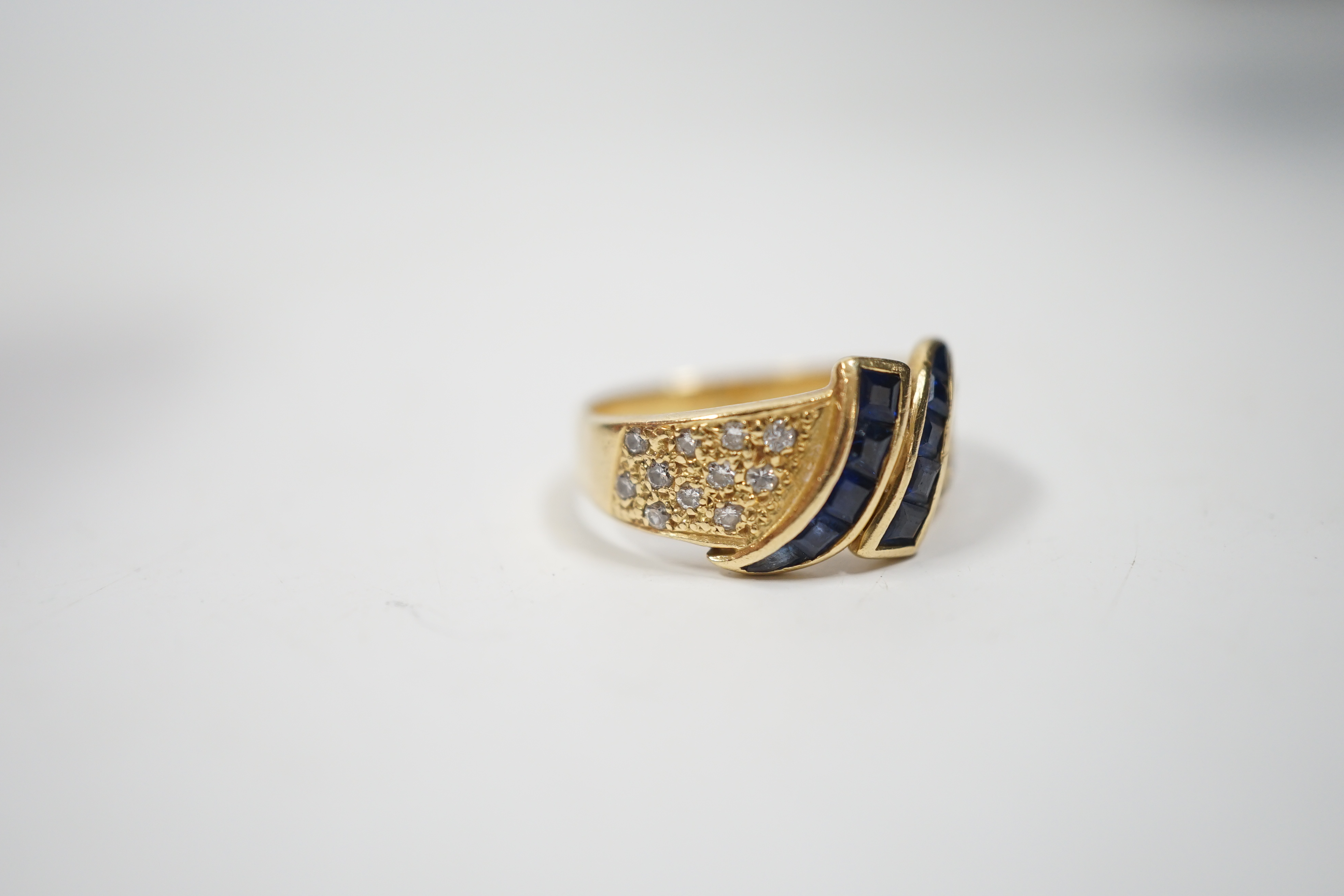 A modern 750 yellow metal, sapphire and diamond chip set dress ring, size K, gross weight 4.8 grams.